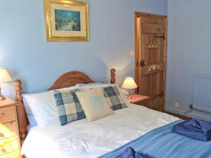 a bedroom with a white bed with two pillows at Isabella Cottage in Heddon on the Wall +4 photos