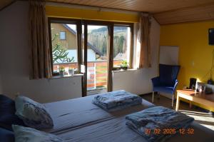 a bedroom with a bed and a window and a desk at Sunrise B&B Hellenthal in Hellenthal