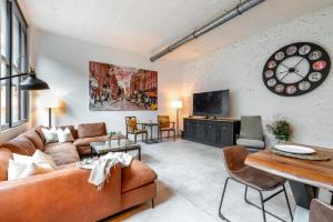a living room with a couch and a clock on the wall at Beautiful Design 2 BR Loft in Mertert