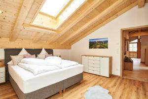 a bedroom with a large white bed and wooden ceilings at Krennlehen in Schönau am Königssee