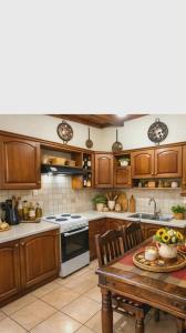 a kitchen with wooden cabinets and a wooden table at green hill studio corfu town in Corfu