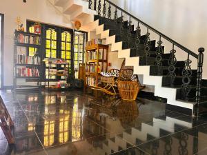 a living room with a staircase and a book shelf at Sea lumina in Varkala