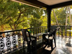 a patio with two chairs and a table on a balcony at Sea lumina in Varkala
