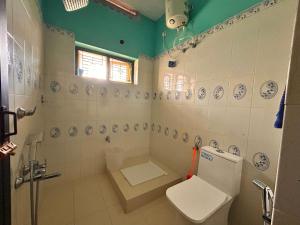 a bathroom with a toilet and a shower and a sink at Sea lumina in Varkala +15 photos