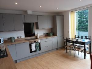 a kitchen with white cabinets and a table and chairs at Stylish 3 Bed Apt Sea Views Near the Beach 2B in Felixstowe