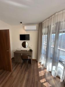 a room with a desk and a tv and a window at Къща за гости Девина in Devin