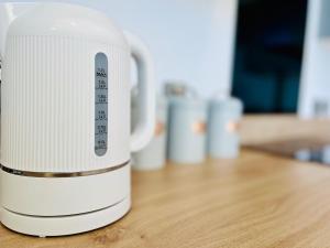 a white toaster sitting on a wooden table at Stylish 3 Bed Apt Sea Views Near the Beach 2B in Felixstowe