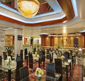 a restaurant with tables and chairs and a chandelier at Admiral Plaza Hotel in Dubai