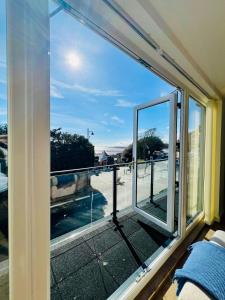 a room with a window with a view of a street at Stylish 3 Bed Apt Sea Views Near the Beach 2B in Felixstowe