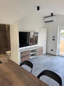 a living room with a television and a table and chairs at Artistik in Vodice