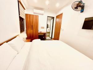 a bedroom with a white bed and a desk at Thanh Phương Hotel 2 Hà Giang in Mèo Vạc +17 photos