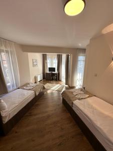 a bedroom with two beds and a living room at Къща за гости Девина in Devin