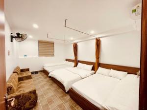 a room with two beds and a couch at Thanh Phương Hotel 2 Hà Giang in Mèo Vạc