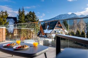 two plates of food on a table on a balcony at Tatra Heaven Residence & Jacuzzi in Kościelisko