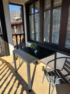 a black table and a chair on a balcony at Къща за гости Девина in Devin
