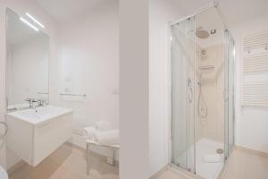 a white bathroom with a shower and a sink at Felix Hotels - Residence Hotel Grandi Magazzini in Nuoro +52 photos