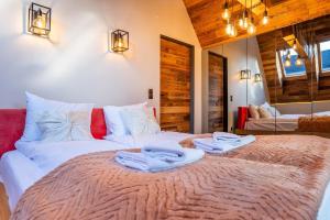 a bedroom with a large bed with towels on it at Tatra Heaven Residence & Jacuzzi in Kościelisko