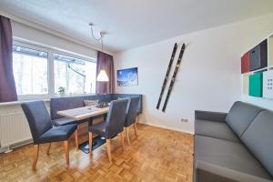 ein Esszimmer mit einem Tisch, Stühlen und einem Sofa in der Unterkunft Appartement Relax & Sport in Saalbach-Hinterglemm