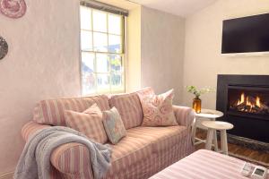 a living room with a couch and a fireplace at Clonmara Country House and Cottages in Port Fairy