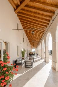 an open hallway with a wooden ceiling and chairs and flowers at Casa de Eli - Tenuta Torre Zecchei Wine Experience in Valdobbiadene