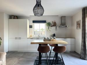 eine Küche mit einem Holztisch und Hockern in der Unterkunft 't Klein Uusje in Torhout
