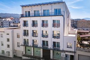 a white building with balconies on the side of it at Felix Hotels - Residence Hotel Grandi Magazzini in Nuoro