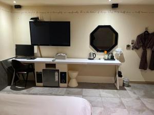a desk with a computer and a monitor on a wall at Sixty Hotel in Seoul