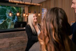 a woman standing in a bar talking to another woman at Landhotel Moorhof in Neuschönau