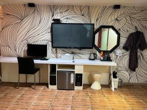 a desk with a television on top of a wall at Sixty Hotel in Seoul
