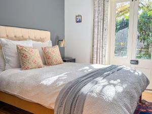 a bedroom with a large bed with a window at Clonmara Country House and Cottages in Port Fairy +35 photos