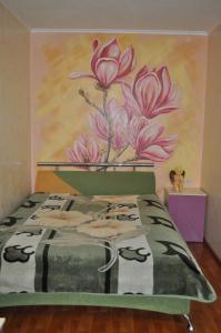 ドニプロにあるApartment on Oleksandra Polia Avenue 110のピンクの花の絵が飾られたベッドルーム