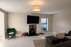 a living room with a flat screen tv on the wall at Private room in shared house at Casa de Charlie in Lambeg