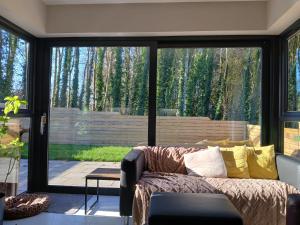 a living room with a couch and a large window at Private room in shared house at Casa de Charlie in Lambeg