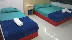 two beds in a room with blue and red at Batu Caves Paradise Hotel in Kuala Lumpur +9 photos