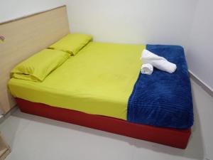 a bed in a room with a towel on it at Batu Caves Paradise Hotel in Kuala Lumpur
