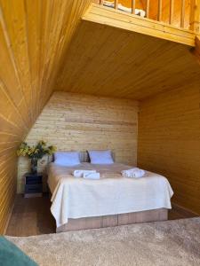 a bedroom with a bed in a wooden room at Son-Kul A-Frame & Yurt Camp in Song-Kul