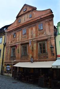 an old building with an awning on a street at Penzion Na Louži in Český Krumlov