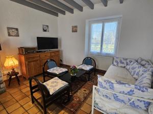 a living room with a couch and chairs and a tv at "la maison de rolland" in Saint-Martin-lʼArs