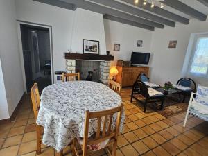 a living room with a table and a fireplace at "la maison de rolland" in Saint-Martin-lʼArs