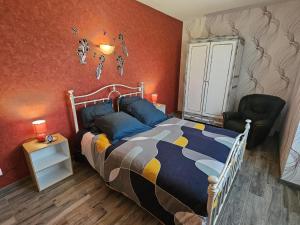 a bedroom with a bed and a chair at "la maison de rolland" in Saint-Martin-lʼArs