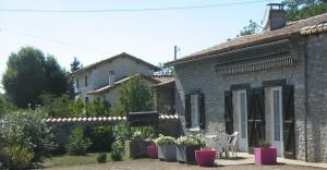 a stone house with a table and chairs in a yard at "la maison de rolland" in Saint-Martin-lʼArs +12 photos
