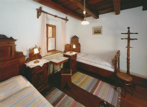a bedroom with two beds and a table and a couch at Penzion Na Louži in Český Krumlov