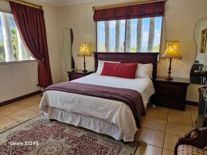 a bedroom with a large bed with two windows at Villa Sardinia Guest House in Midrand +9 photos