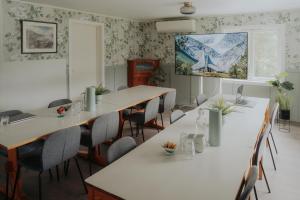 a room with tables and chairs and a painting on the wall at Villa Fjellheim in Luster
