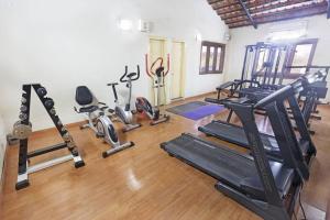 a gym with several treadmills and exercise machines at HM Suites & Studios in Bangalore