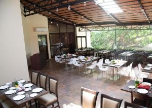 a dining room with tables and white chairs and tablesearcher at HM Suites & Studios in Bangalore
