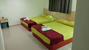 two twin beds in a room with at Batu Caves Paradise Hotel in Kuala Lumpur