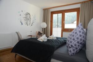 ein Schlafzimmer mit einem Bett mit Kissen und einem Fenster in der Unterkunft Pension Eule in Sankt Kanzian am Klopeiner See
