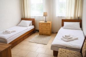 a room with two beds and a table and two windows at Dusan Apartments in Orlová +5 photos