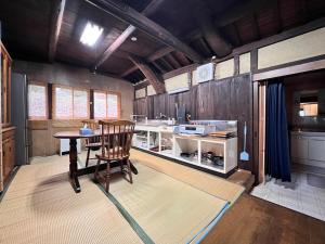a kitchen with a table and a chair in a room at 瀬戸内海を望む庭付き古民家サウナ宿 一棟貸切 in Takamatsu